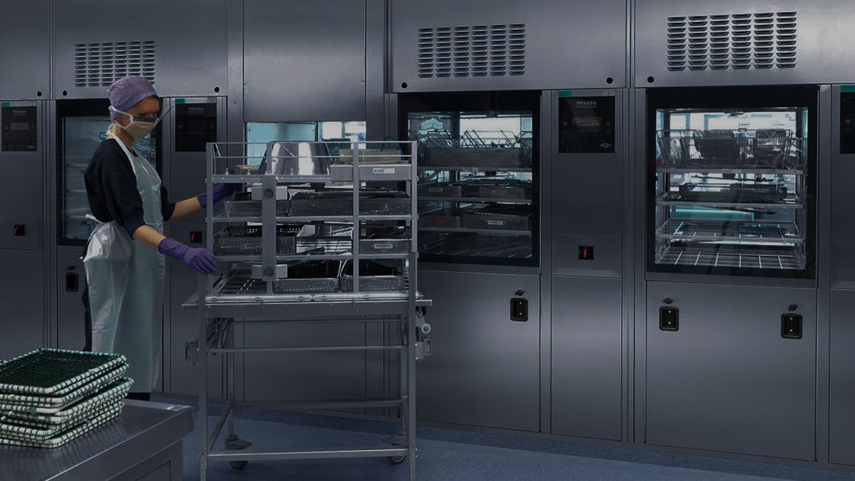 Medical instrument sterilization room with technician pushing sterile cart