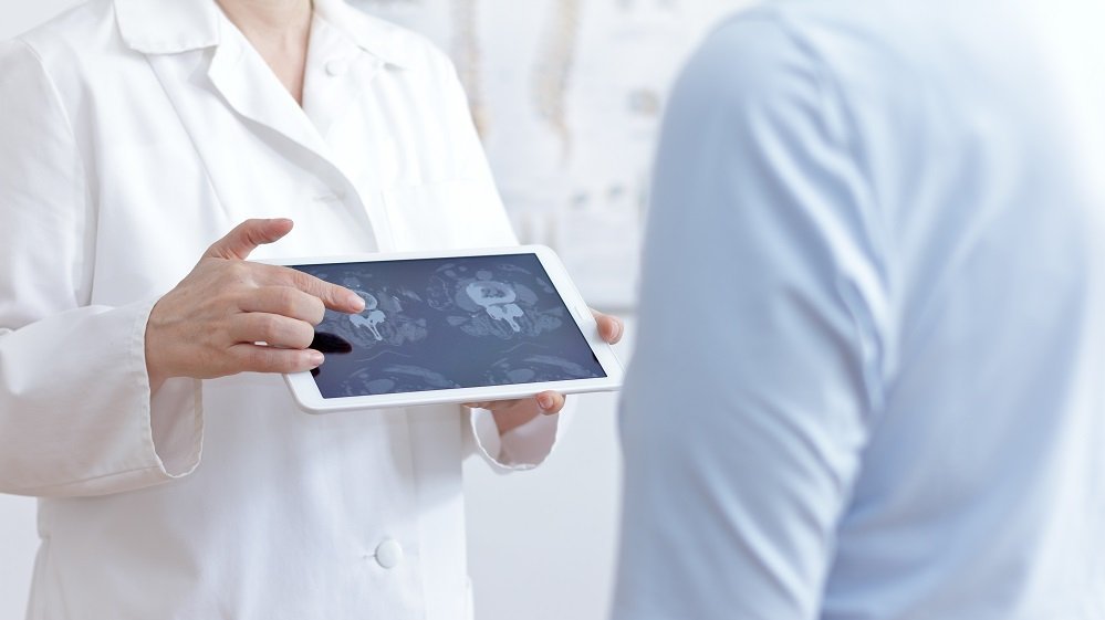 riwospine-digital-treatment-planning-tablet-consultation.png Doctor using tablet for spine treatment planning – digital consultation and personalized care